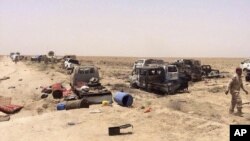 نیروهای امنیتی عراقی در ال بررسی خودروهای منهدم شده پیکارجویان داعش که در حال فرار از فلوجه بودند - ۹ تیر ۱۳۹۵ 
