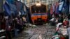 Thailand’s government wants to upgrade the national rail system. Venders pull back awnings and vegetables as a train arrives in Maeklong, in Samut Songkhram province, Aug. 16, 2012.