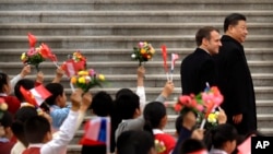 Presiden Perancis Emmanuel Macron (kiri) dan Presiden China Xi Jinping disambut anak-anak yang membawa bendera Perancis dan China di Aula Agung Rakyat di Beijing, 6 November 2019.