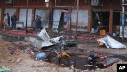 Security forces inspect scene of suicide bombing at a coffee shop, Kirkuk, Iraq, July 13, 2013.