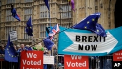 Leave and remain supporters try to block each others banners as they protest opposite Parliament Square in London, Sept. 3, 2019. 