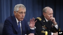 美国国防部长哈格尔（左）与美国参谋长联席会议邓普西12月19日在国防部举行的记者会上