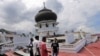 Warga memeriksa sebuah masjid yang amblas karena gempa di Pidie Jaya, Aceh (7/12). (AP/Heri Juanda)
