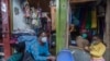 A woman and her child wear face masks as preventive measure against the COVID-19, in her shop inLilongwe City market in Lilongwe, Malawi, May 18, 2020.