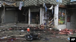 Seorang petugas keamanan Afghanistan memeriksa lokasi pemboman bunuh diri dekat sebuah bank di Jalalabad, Kabul timur, Afghanistan, 18 April 2015. 