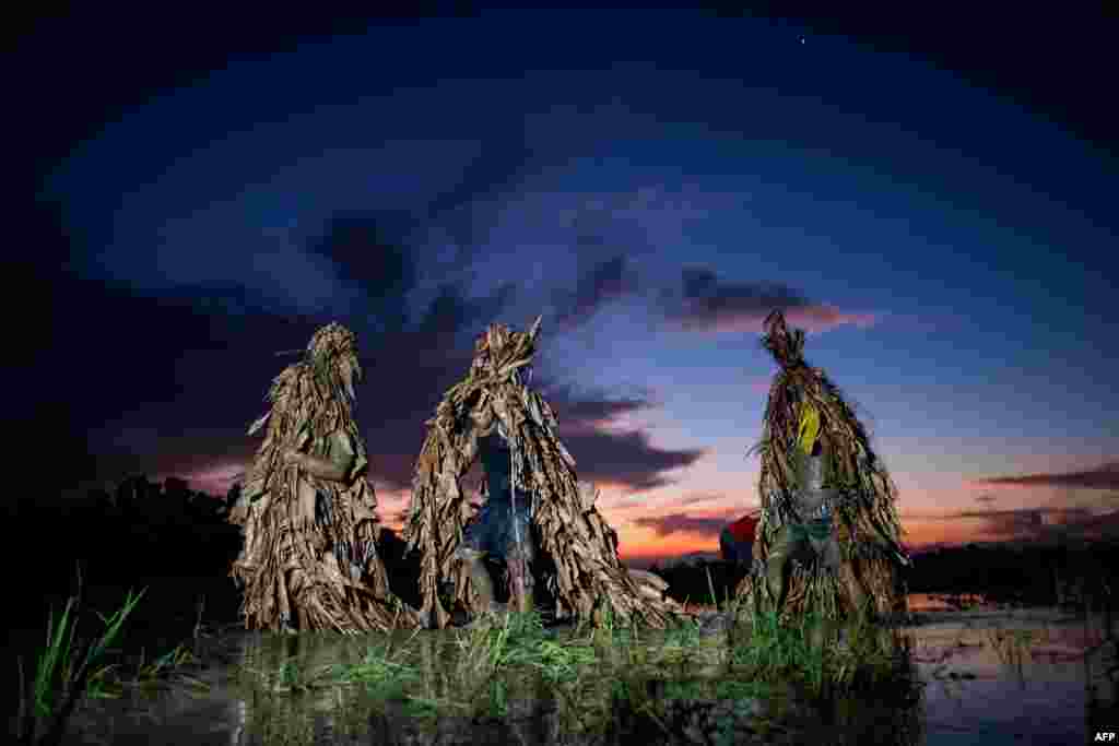 Devotees wear costumes made of banana leaves as they head to church to attend Mass as part of a religious festival, in honor of St. John the Baptist, also known locally as the &quot;mud people&quot; festival, in Aliaga town, Nueva Ecija province, north of Manila, Philippines.