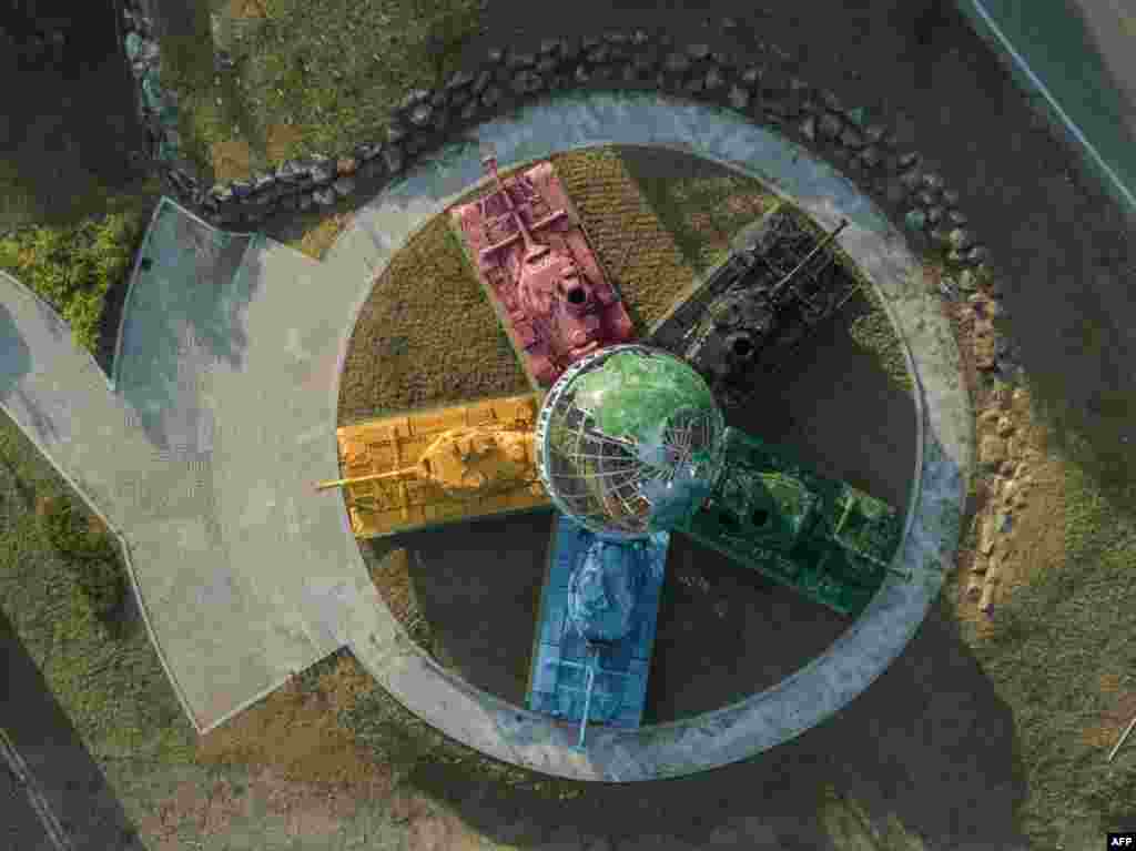 An aerial view of an art installation featuring Korean war-era tanks painted in different colors around a globe with a slogan reading: &#39;Peace All Around the World&#39;, at the Peace dam, north of Hwacheon near the Demilitarized Zone (DMZ) separating North and South Korea, May 21, 2017.