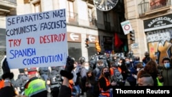 A protester holds a placard during a demonstration organized by Spain's far-right party Vox, against the central government, in Barcelona, Spain, December 6, 2020.