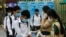 Students disinfect their hands to avoid the contact of coronavirus before their morning class at Santhormok high school, in Phnom Penh, Cambodia, Monday, Nov. 2, 2020. (AP Photo/Heng Sinith)
