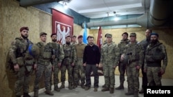 乌克兰总统办公室新闻处公布的照片显示乌克兰总统泽连斯基与乌克兰武装部队司令瑟尔斯基将军在苏梅地区与阵地上的乌克兰军人合影。(2024年10月4日).