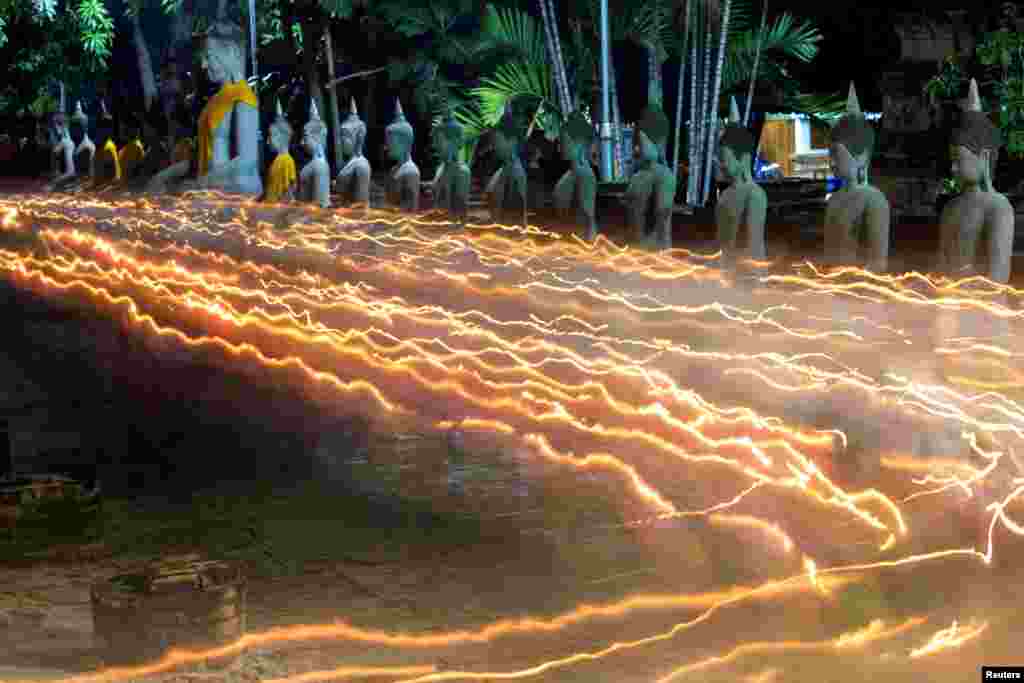 Buddhists carry candles as they pray during Vesak Day, an annual celebration of Buddha&#39;s birth, at Wat Yai Chai Mongkhon temple in Ayutthaya, Thailand.