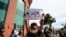 A protester raises a fist as thousands gather outside City Hall against the death in Minneapolis police custody of George Floyd, in front of City Hall in Seattle, June 1, 2020.