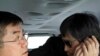 In this photo released by the US Embassy Beijing Press Office, blind lawyer Chen Guangcheng makes a phone call as he is accompanied by U.S. Ambassador Gary Locke on the way to a hospital in Beijing, May 2, 2012.