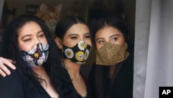 Anissa Archuleta, center, sits at a window with her sister Alexis Archuleta, right, and her mother Jaime Ortega, at their home in Midvale, Utah, May 18, 2020.