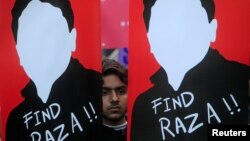 FILE - A demonstrator holds placards calling for the release of Raza Mehmood Khan, a member of Aghaz-e-Dosti (Start of Friendship), during a protest in Lahore, Pakistan, Dec. 11, 2017. Kahn resurfaced last week in Lahore.