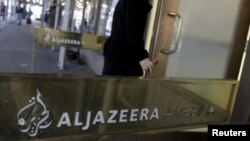 Un employé pénètre dans le centre de diffusion d'Al Jazeera America dans le centre de Manhattan à New York.