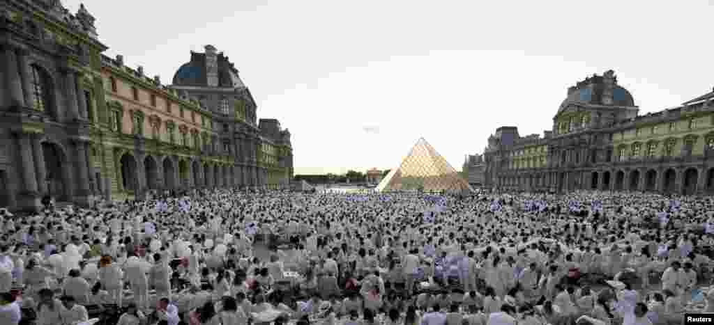 2013年6月13日，人们聚集在卢浮宫前面的广场参加白色晚宴。人们要穿白色服装，自带食物