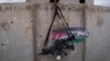 Dua senapan M-16 tergantung di dinding dengan grafiti yang menampilkan bendera Palestina di Pusat Pelatihan Perang Kota IDF di pangkalan militer Zeelim, Israel selatan, 10 Februari 2022. (Foto: AP)