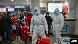 资料照：武汉红十字医院身穿防护服的医务人员和等候就诊的病患。（2020年1月25日）