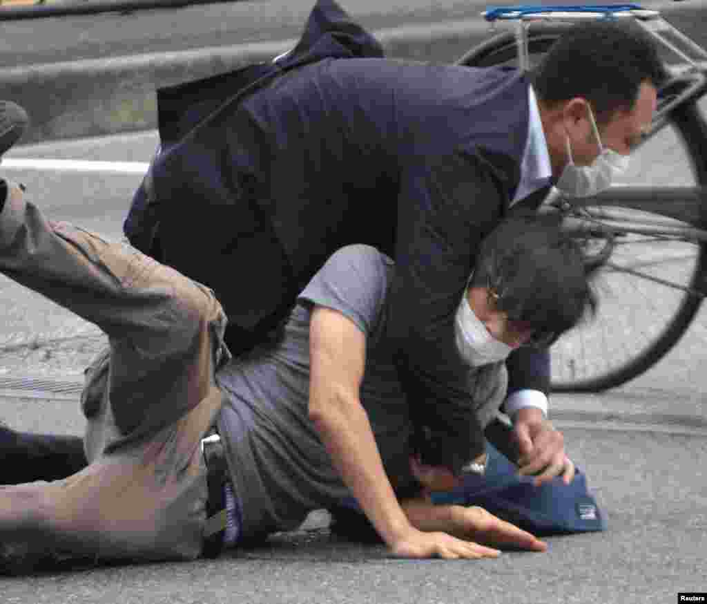 A man, believed to be a suspect shooting former Japanese Prime Minister Shinzo Abe, is held by police officers at Yamato Saidaiji Station in Nara, Nara Prefecture, July 8, 2022 in this photo taken by the Yomiuri Shimbun.&nbsp;