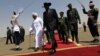South Sudanese President Salva Kiir (C) walks with his Sudanese counterpart Omar al-Bashir (in white) before Kiir's departure from Khartoum, October 9, 2011. 