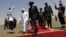 South Sudanese President Salva Kiir (C) walks with his Sudanese counterpart Omar al-Bashir (in white) before Kiir's departure from Khartoum, October 9, 2011. 