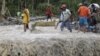 Residents cross a river with the body of a child after retrieving it from the flash flood-hit village of Andap, in New Bataan township, Compostela Valley in southern Philippines, December 5, 2012.
