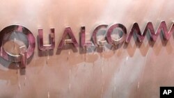FILE - The Qualcomm logo is seen at an exhibit at the Consumer Electronics Show in Las Vegas.