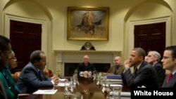 President Barack Obama drops by a meeting with President Hassan Sheikh Mohamud of Somalia and Deputy National Security Advisor Denis McDonough in the Roosevelt Room of the White House, Jan. 17, 2013.