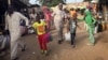 People walk to the ferry heading toward Senegal in Gambia's capital, Banjul, Jan. 17, 2017. Gambia's President Yahya Jammeh declared a state of emergency just two days before he is supposed to cede power after losing elections last month to Adama Barrow. 
