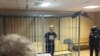 Russian investigative journalist Ivan Golunov stands inside a defendants' cage during a court hearing in Moscow, Russia on June 8, 2019.