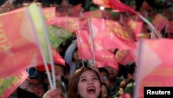 在台北民进党总部外的蔡英文总统的支持者举旗欢呼。（2020年1月11日）