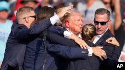 የቀድሞው የዩናይትድ ስቴትስ ፕሬዝዳንት እና የሪፐብሊካን ፕሬዝዳንታዊ እጩ ዶናልድ ትራምፕ፣ ቅዳሜ ሐምሌ 6 ቀን 2016 ዓ.ም. በፔንሰልቬኒያ፣ ባትለር ውስጥ ጥቃት ከደረሰባቸው በኋላ የምርጫ ቅስቀሳ ያደርጉበት ከነበረው መድረክ እንዲወርዱ በሰዎች ሲረዱ