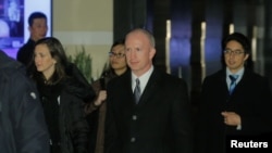 美国副贸易代表格里什（中）2019年1月7日离开北京一家酒店前往谈判会场