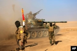 FILE - Fighters of the Popular Mobilization Forces at the front line against Islamic State Group militants outside Mosul, Iraq, Nov. 26, 2016.