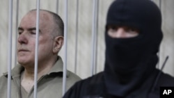 Mantan pejabat tinggi intelijen Ukraina, Olexiy Pukach (kiri) divonis bersalah dalam pengadilan di ibukota Kiev, hari Selasa (29/1).