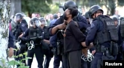 Police arrest a pro-Palestinian protester at USC campus in Los Angeles, California, U.S., April 25, 2024, as seen in this screen grab obtained from a video. (Video obtained by Reuters/via Reuters)
