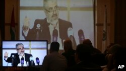 하마스 지도자 칼리드 마슈알이 1일 카타르 도하에서
가진 기자회견을, 가자시티의 하마스 관계자들이
중계화면으로 보고 있다.