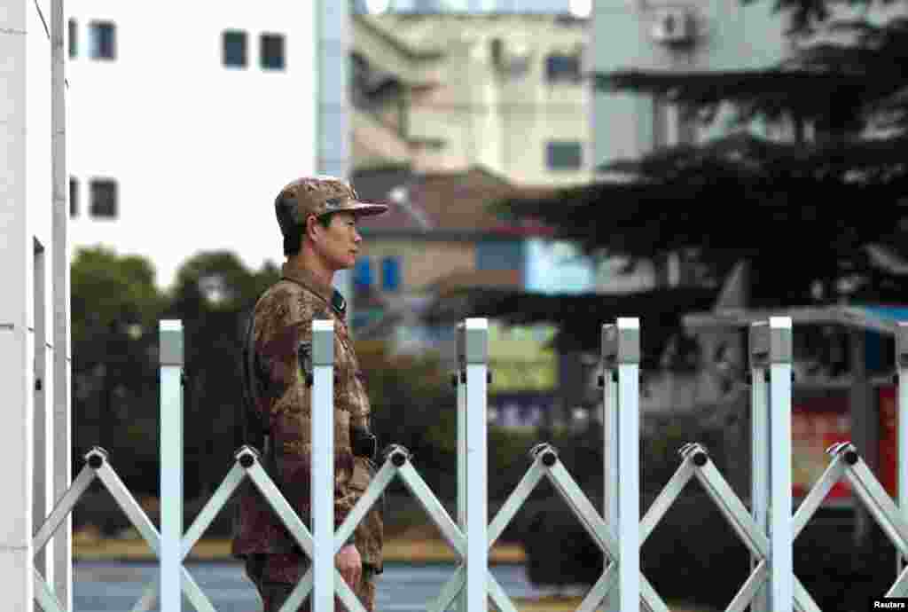 一名中国人民解放军士兵在上海的61398部队驻地门口站岗。曼迪昂特公司报告说，中国黑客的重点是从外国公司窃取技术图纸、制造流程等信息。