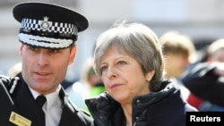 La Première ministre britannique Theresa May, lors de sa visite dans la ville où l'ancien espion russe Sergei Skripal et sa fille Yulia ont été empoisonnés à Salisbury, en Grande-Bretagne, le 15 mars 2018. 