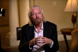 FILE - Virgin Galactic founder Richard Branson speaks during an interview while attending the Space Symposium in Colorado Springs, Colorado, April 11, 2019.
