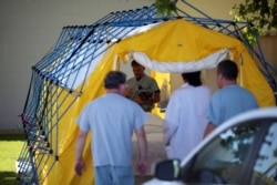 FILE - Hospital workers set up equipment outside the Ridgecrest Regional Hospital after a powerful earthquake struck Southern California in the city of Ridgecrest, California, July 4, 2019.