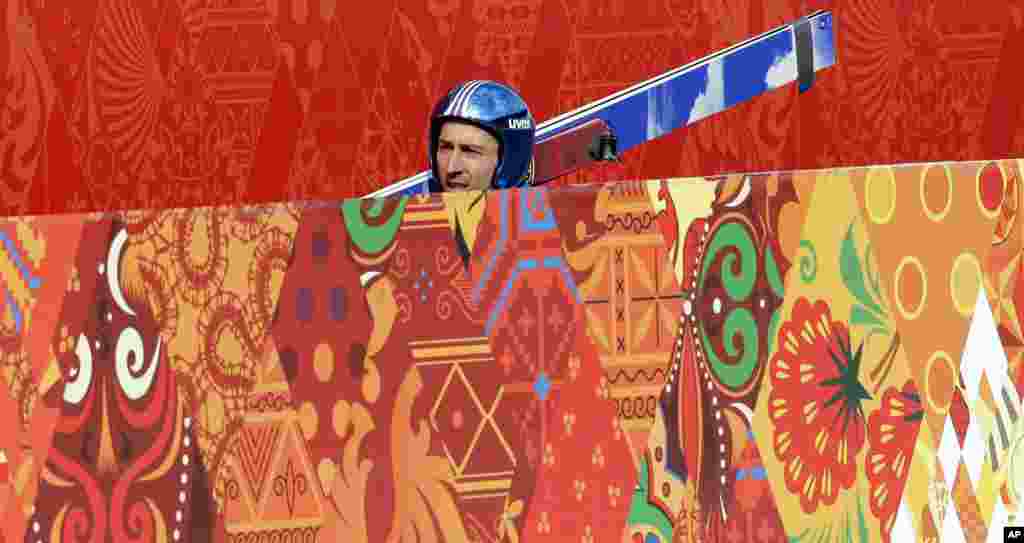 Wilhelm Denifl dari Austria membawa alat skinya dalam latihan di stadion ski di Krasnaya Polyana, Rusia (10/2). (AP/Matthias Schrader)