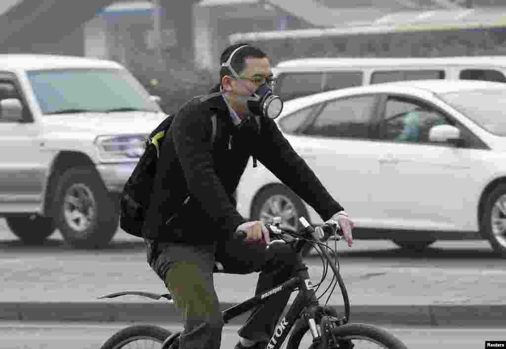 A man wearing a mask rides a bicycle during a smoggy day in Beijing. China's Environment Ministry said last week it will send inspection teams to provinces and cities most seriously affected by smog to ensure rules on fighting air pollution are being enforced.