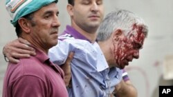 In this photo taken on Wednesday July 24 2013, train driver Francisco Jose Garzon Amo is helped by two men as he is evacuated from the site of a train accident in Santiago de Compostela, Spain.