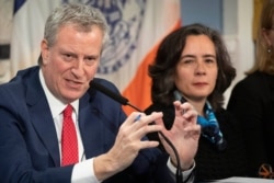 FILE - Mayor Bill de Blasio, left, holds a press conference in New York, Feb. 26, 2020.