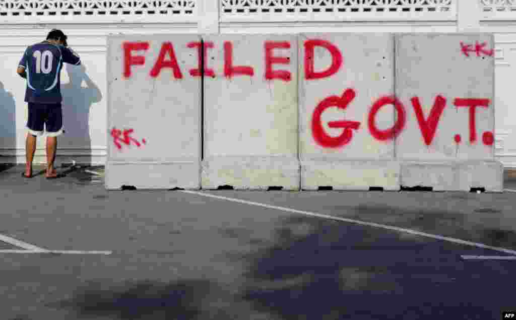 Thai anti-government protester washes his face at a protest site outside the Government House in Bangkok.
