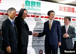 日本首相安倍晋三（中右）等人在选举之夜的活动中。