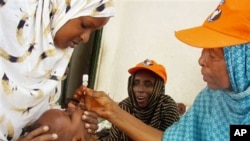 Wata jami'a ta Hukumar Kiwon lafiya ta Duniya tana diga ma wani jariri maganin rigakafin cutar Polio a Mogadishu, Somaliya.