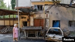 ፋይል፤ እንደ አውሮፓውያን የቀን አቆጣጠር ጁላይ 22 ቀን 2024 ዓ.ም. ሩሲያ ጥቃት ባደረሰችበት ዶነስክ ግዛት አካባቢ በሚገኝ መንደር ውስጥ አንዲት እናት የፈራረሰውን መንደር ቆመው ሲመለከቱ። 